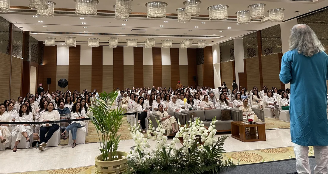 Bawa addressing a large audience in white